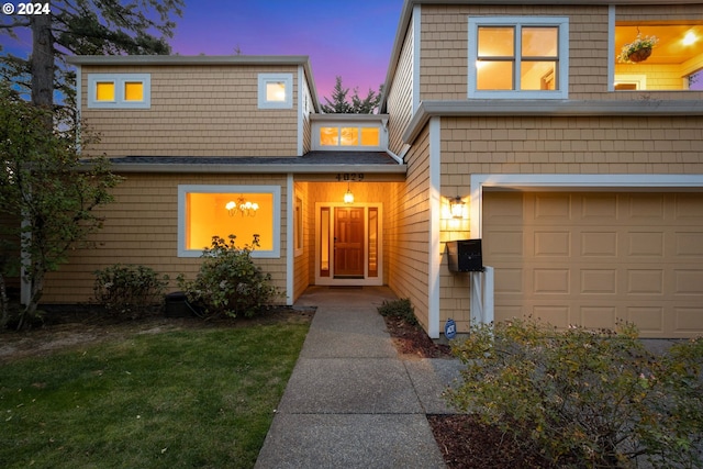 view of front of property featuring a garage and a lawn