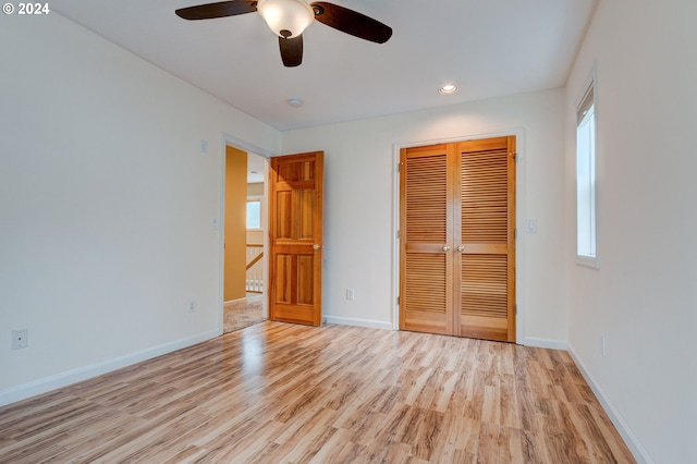 unfurnished bedroom with light hardwood / wood-style flooring, a closet, and ceiling fan