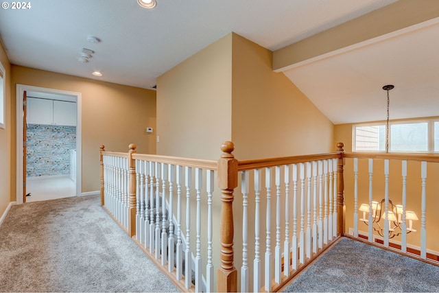 hallway with carpet flooring and vaulted ceiling