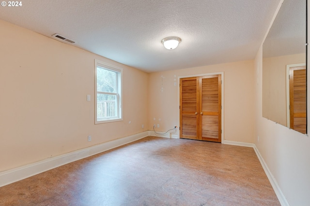 unfurnished room with a textured ceiling