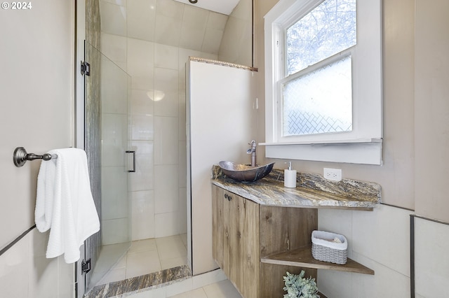 bathroom featuring tile patterned flooring, a shower with door, and sink