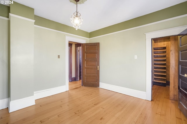 unfurnished room with hardwood / wood-style floors and an inviting chandelier