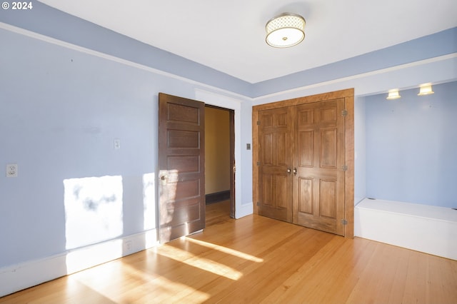 unfurnished bedroom featuring wood-type flooring and a closet