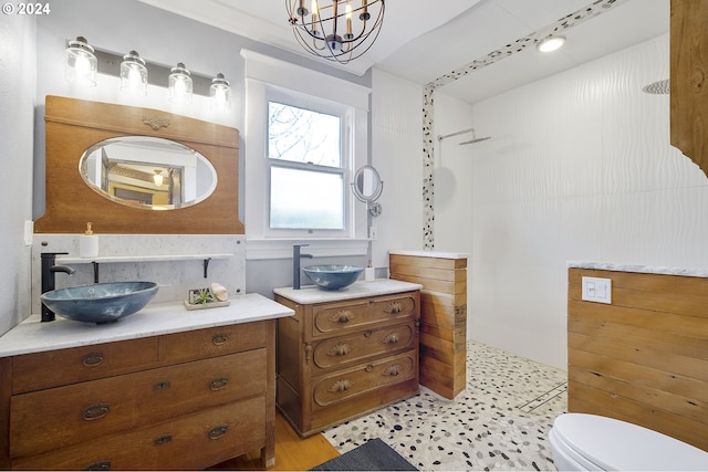 bathroom with vanity, toilet, walk in shower, and an inviting chandelier