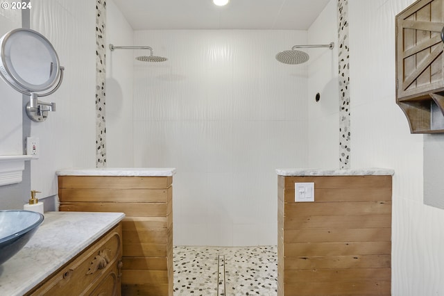 bathroom featuring a tile shower and vanity