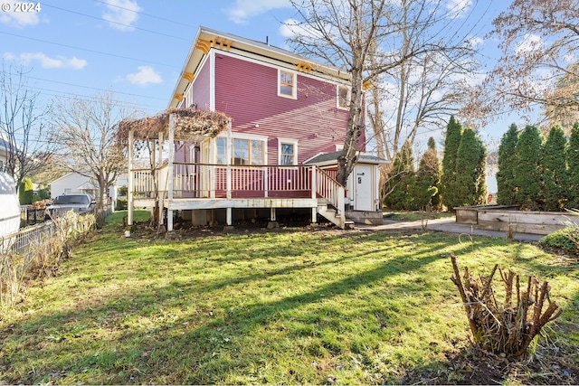 rear view of property featuring a lawn and a wooden deck