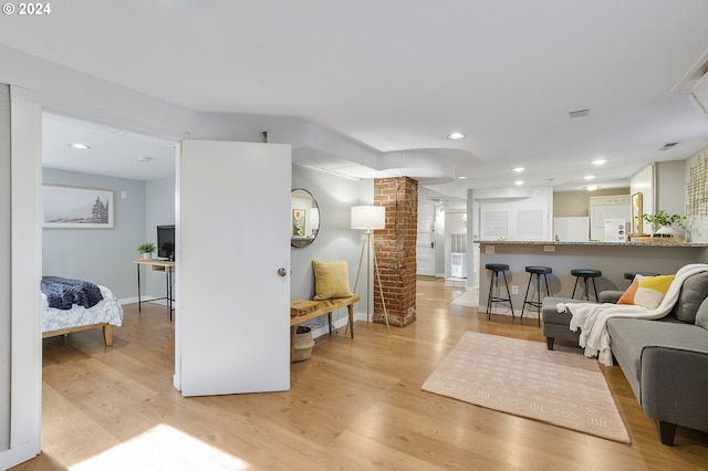 living room with light hardwood / wood-style floors and decorative columns