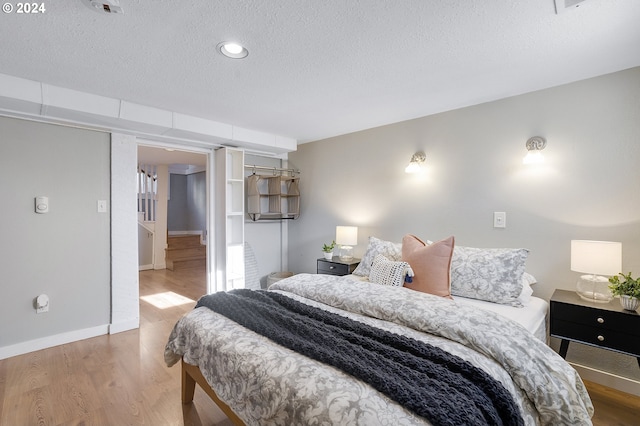 bedroom featuring a textured ceiling and hardwood / wood-style flooring