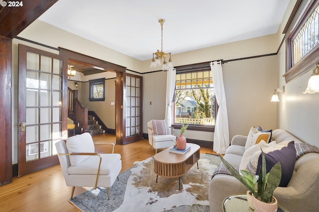 sitting room with a chandelier, french doors, and light hardwood / wood-style floors