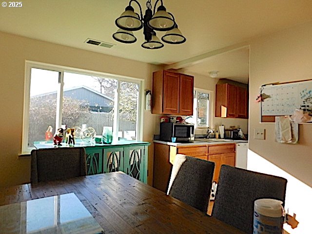 kitchen with sink, dishwasher, and a notable chandelier