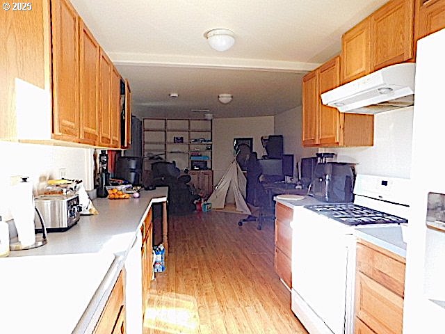 kitchen with white range with gas stovetop and light hardwood / wood-style floors