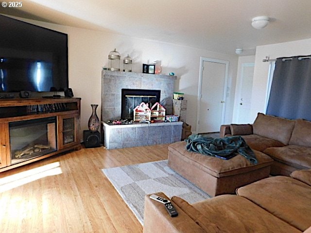 living room with a tile fireplace and wood-type flooring