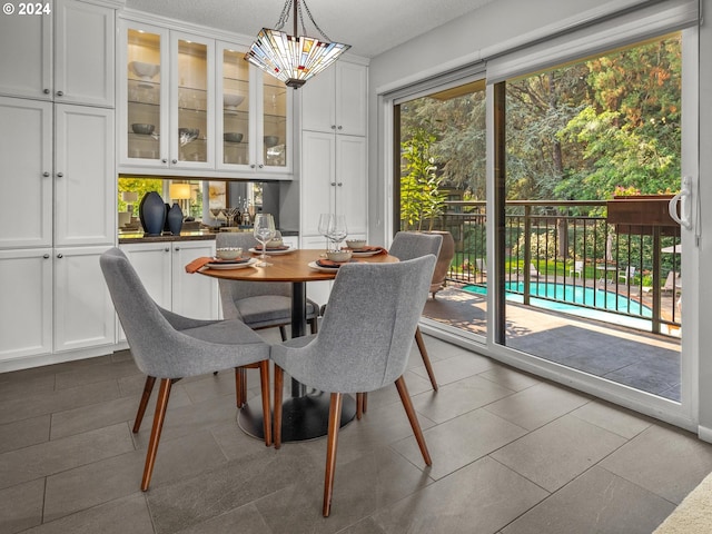 dining area featuring a chandelier, a textured ceiling, and light tile patterned floors