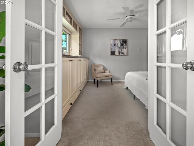 bedroom featuring ceiling fan, light carpet, and french doors