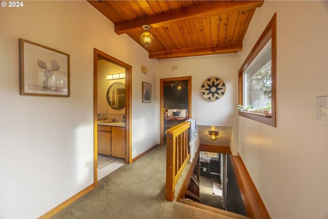 bedroom featuring carpet, vaulted ceiling with beams, and wood ceiling