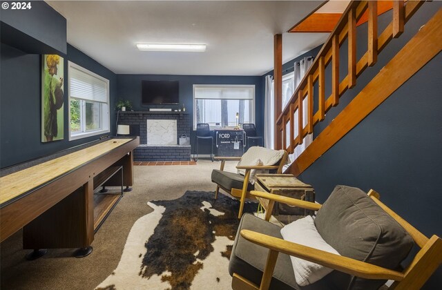 recreation room with carpet flooring, a brick fireplace, and a wealth of natural light