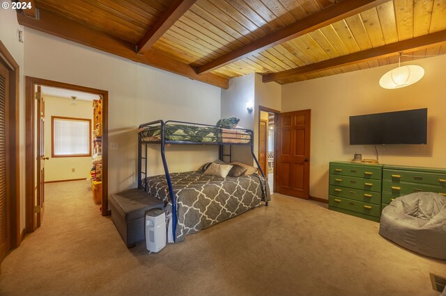 living area with beam ceiling, plenty of natural light, and carpet floors