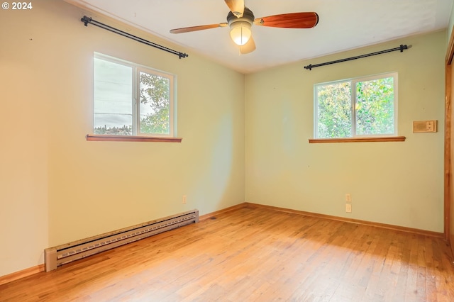 spare room with light wood-type flooring, plenty of natural light, a baseboard heating unit, and ceiling fan