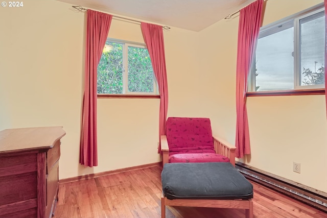 sitting room with hardwood / wood-style flooring and a baseboard radiator