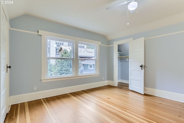 unfurnished bedroom featuring hardwood / wood-style flooring, vaulted ceiling, and a closet