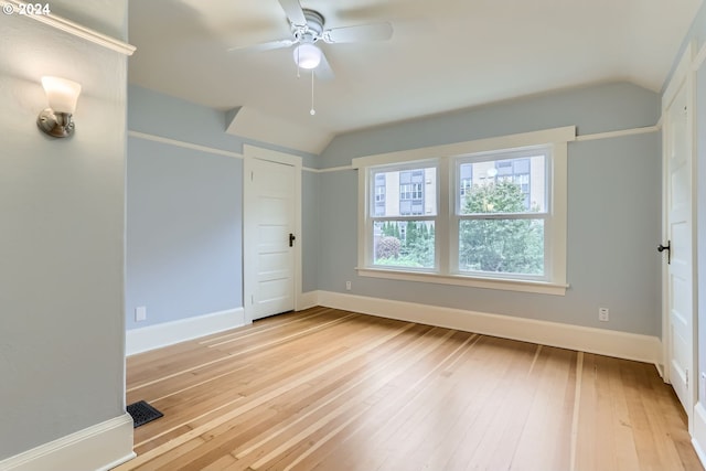 spare room featuring ceiling fan, light hardwood / wood-style flooring, and lofted ceiling