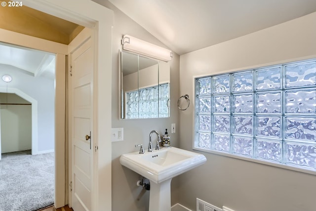 bathroom featuring sink and lofted ceiling