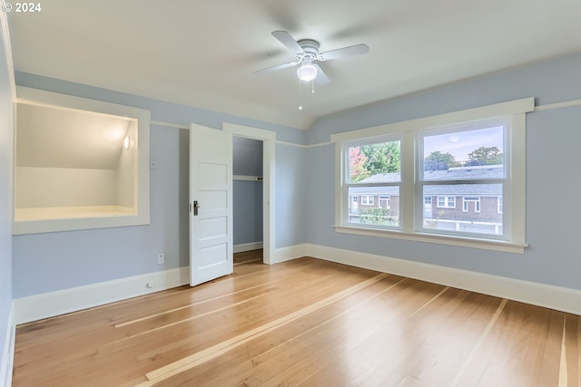 unfurnished bedroom with ceiling fan, vaulted ceiling, wood-type flooring, and a closet