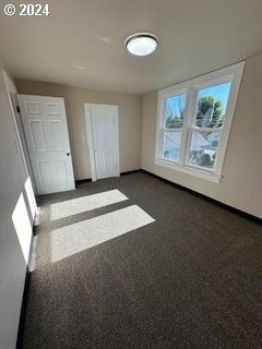 unfurnished bedroom with dark carpet