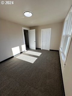 unfurnished bedroom with dark carpet