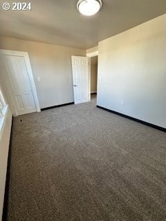 spare room featuring dark colored carpet