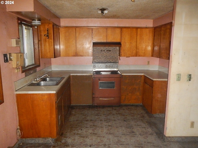 kitchen featuring sink, range, and a textured ceiling