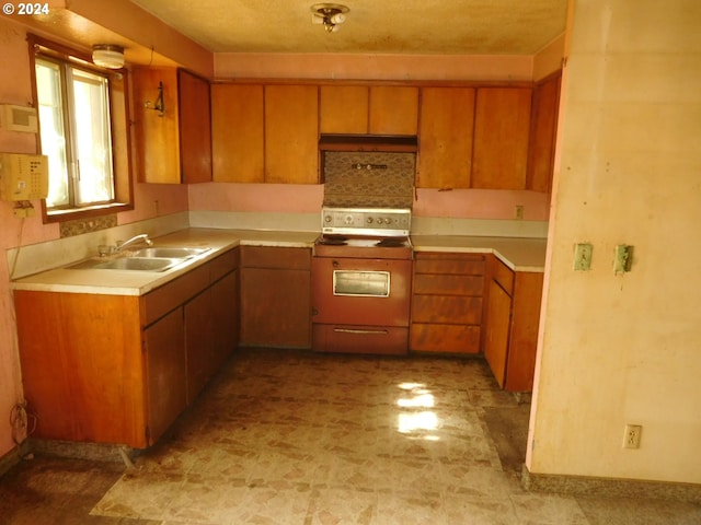 kitchen featuring range, sink, and a textured ceiling