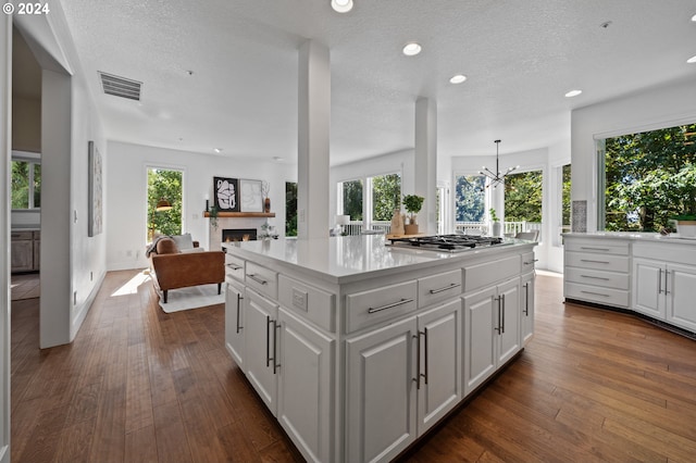 kitchen with a kitchen island, white cabinetry, and a wealth of natural light