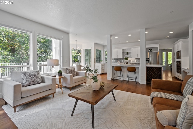 living room featuring light hardwood / wood-style flooring, a textured ceiling, and sink