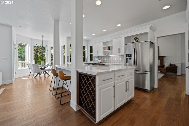 kitchen with dark wood-type flooring, stainless steel appliances, and white cabinets