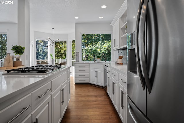 kitchen with white cabinetry, appliances with stainless steel finishes, plenty of natural light, and dark wood-type flooring