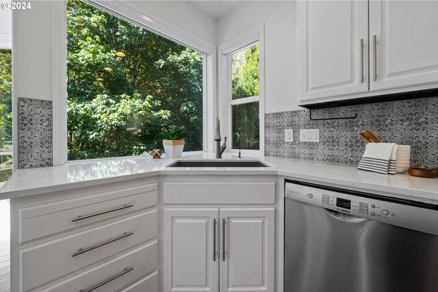 kitchen featuring white cabinetry, dishwasher, sink, and tasteful backsplash