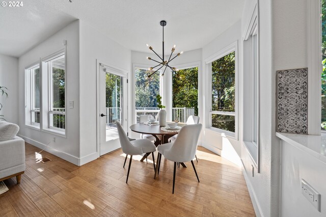 dining space with light hardwood / wood-style flooring and an inviting chandelier