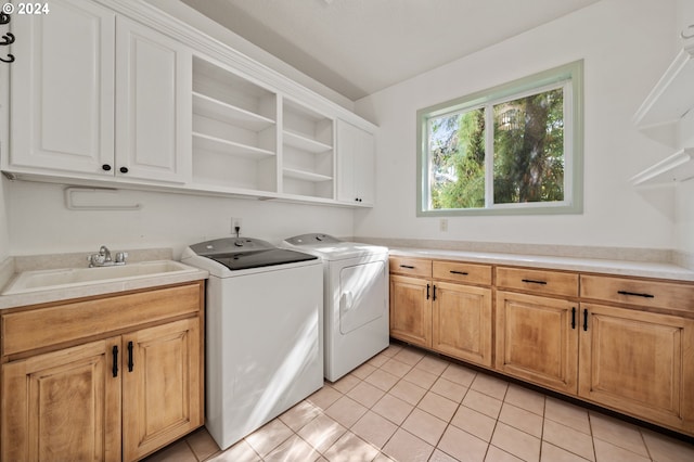 laundry area with separate washer and dryer, cabinets, and light tile patterned flooring