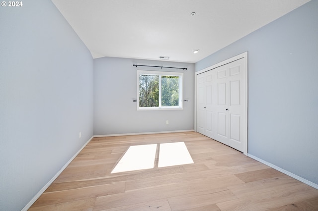 unfurnished bedroom with light hardwood / wood-style flooring and a closet