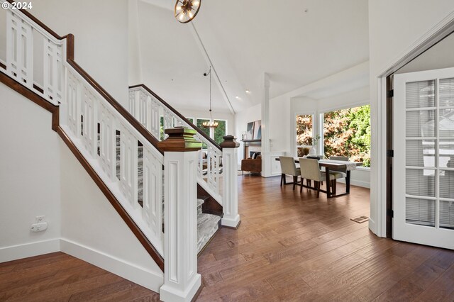 staircase featuring wood-type flooring and a chandelier