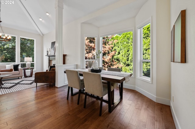 dining space featuring lofted ceiling, dark wood-type flooring, and a notable chandelier