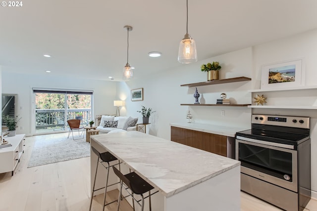 kitchen with white cabinetry, stainless steel range with electric stovetop, a center island, light hardwood / wood-style flooring, and pendant lighting