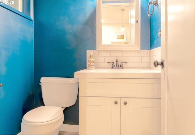 bathroom with tasteful backsplash, vanity, and toilet