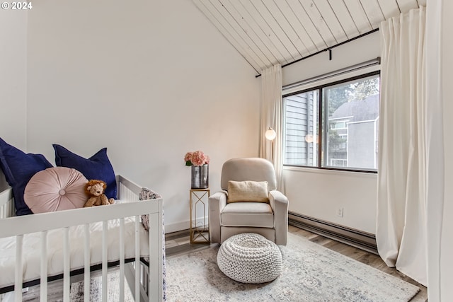 bedroom with lofted ceiling, wood-type flooring, wooden ceiling, a nursery area, and a baseboard radiator