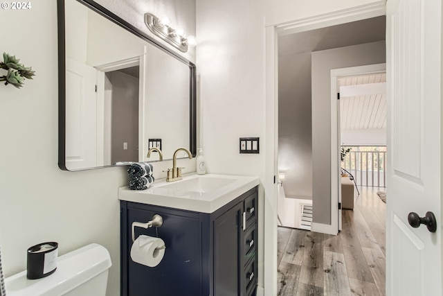 bathroom with vanity, toilet, and hardwood / wood-style floors