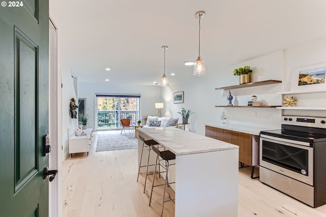 kitchen featuring light hardwood / wood-style flooring, green cabinets, a breakfast bar, decorative light fixtures, and electric stove