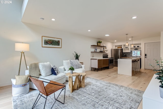 living room with sink and light wood-type flooring