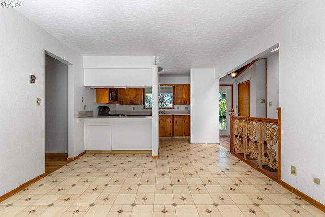 kitchen with a textured ceiling and black appliances