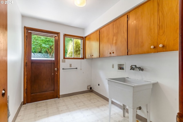 laundry area with hookup for an electric dryer, hookup for a washing machine, and cabinets